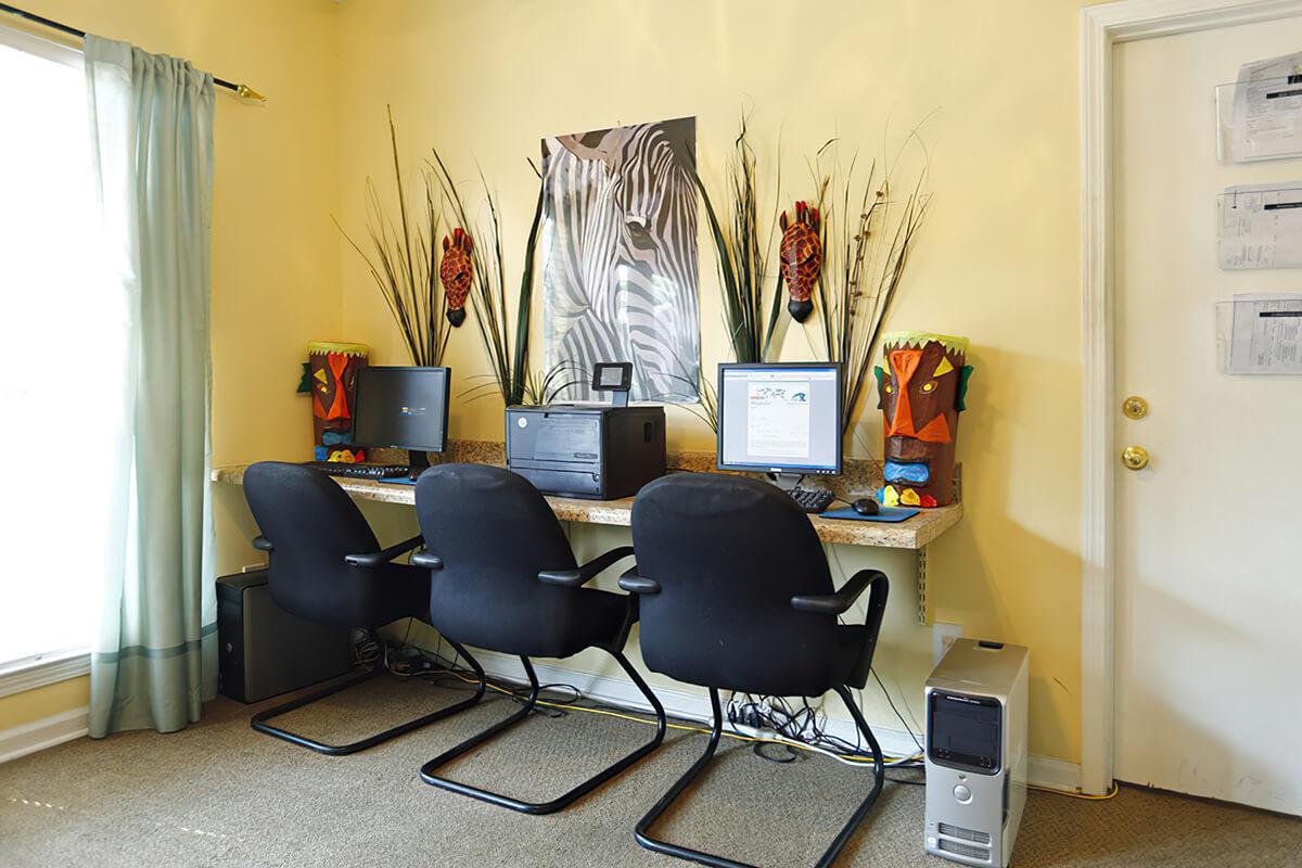 Office space with desks, chairs, and a computer station.